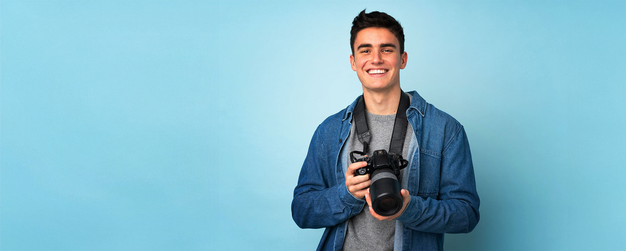 male photographer with camera infront of background